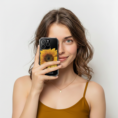 Woman holding a phone with a sunflower case against a plain background