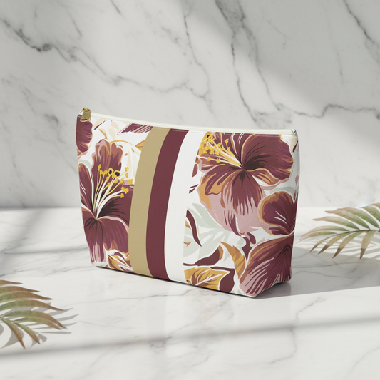 Floral-patterned pouch on a marble surface with palm leaves.