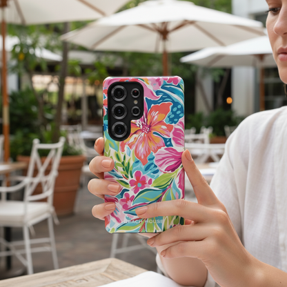 Person holding a Waikiki Tough Case for Galaxy with a colorful floral case in an outdoor setting