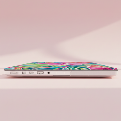 Laptop with a colorful floral Waikiki MacBook Case on a light pink background
