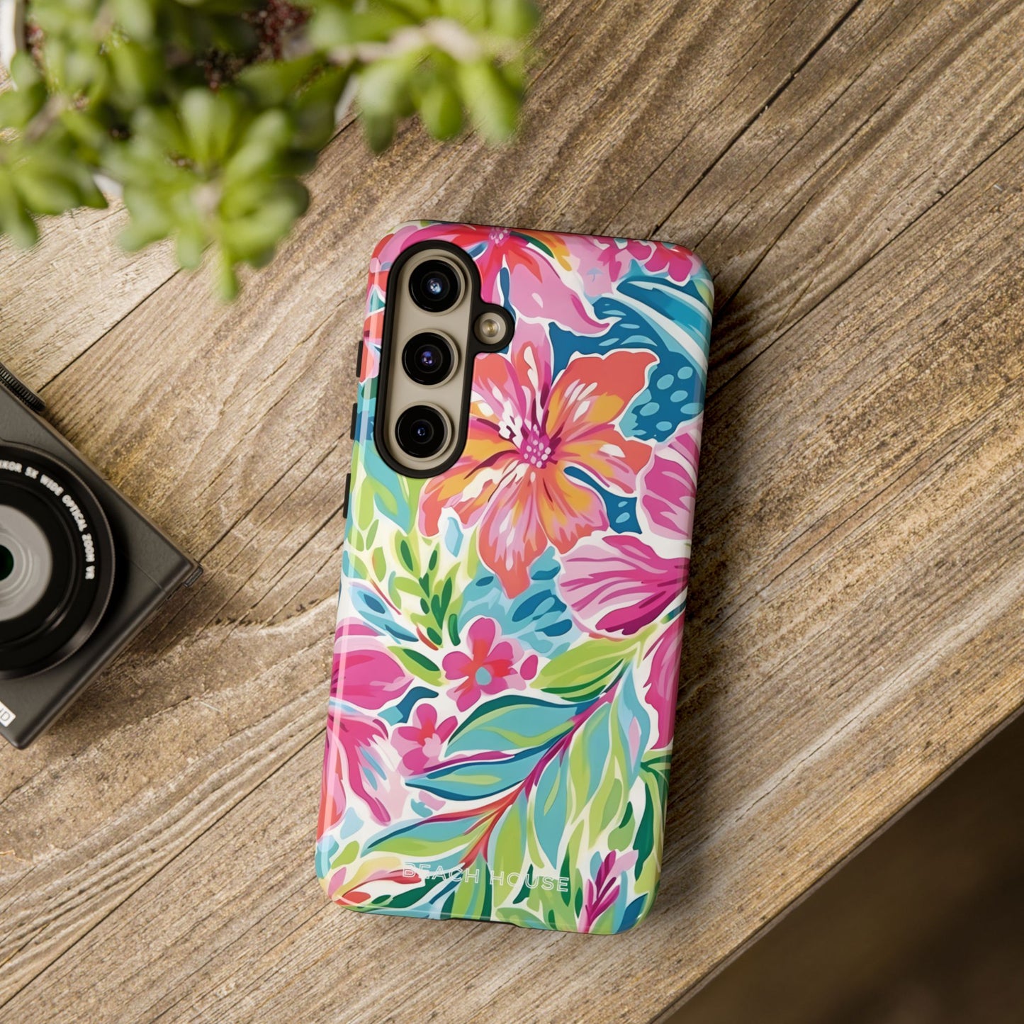 Waikiki Tough Case for Galaxy on a wooden surface with a camera and plant in the background
